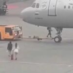 راكبتان يحاولان الصعود إلى طائرة أثناء سحبها في مطار شيريميتيفو.