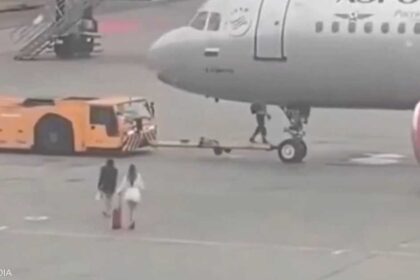 راكبتان يحاولان الصعود إلى طائرة أثناء سحبها في مطار شيريميتيفو.